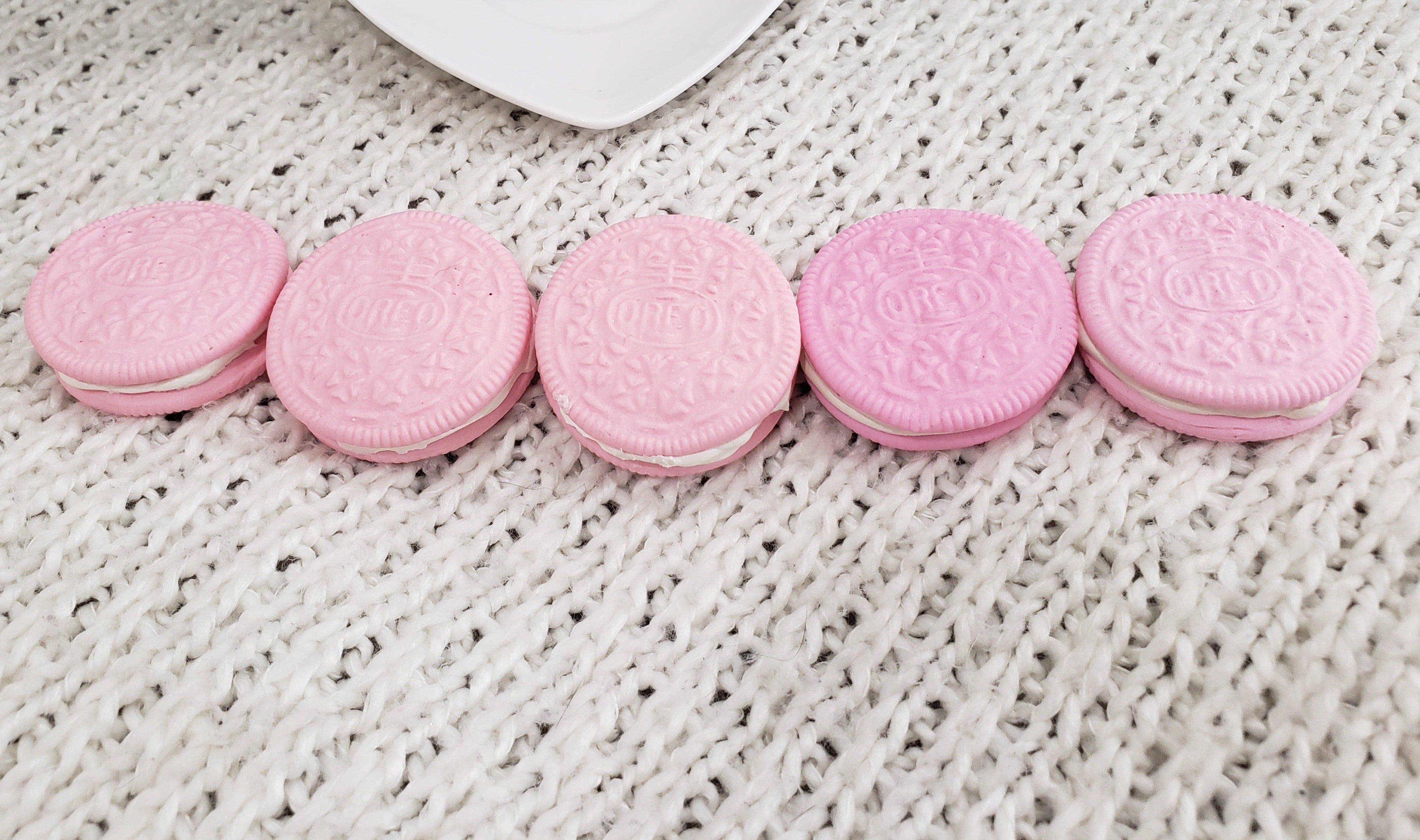 A row of pink Oreo cookies on a white blanket - Oreo, pink