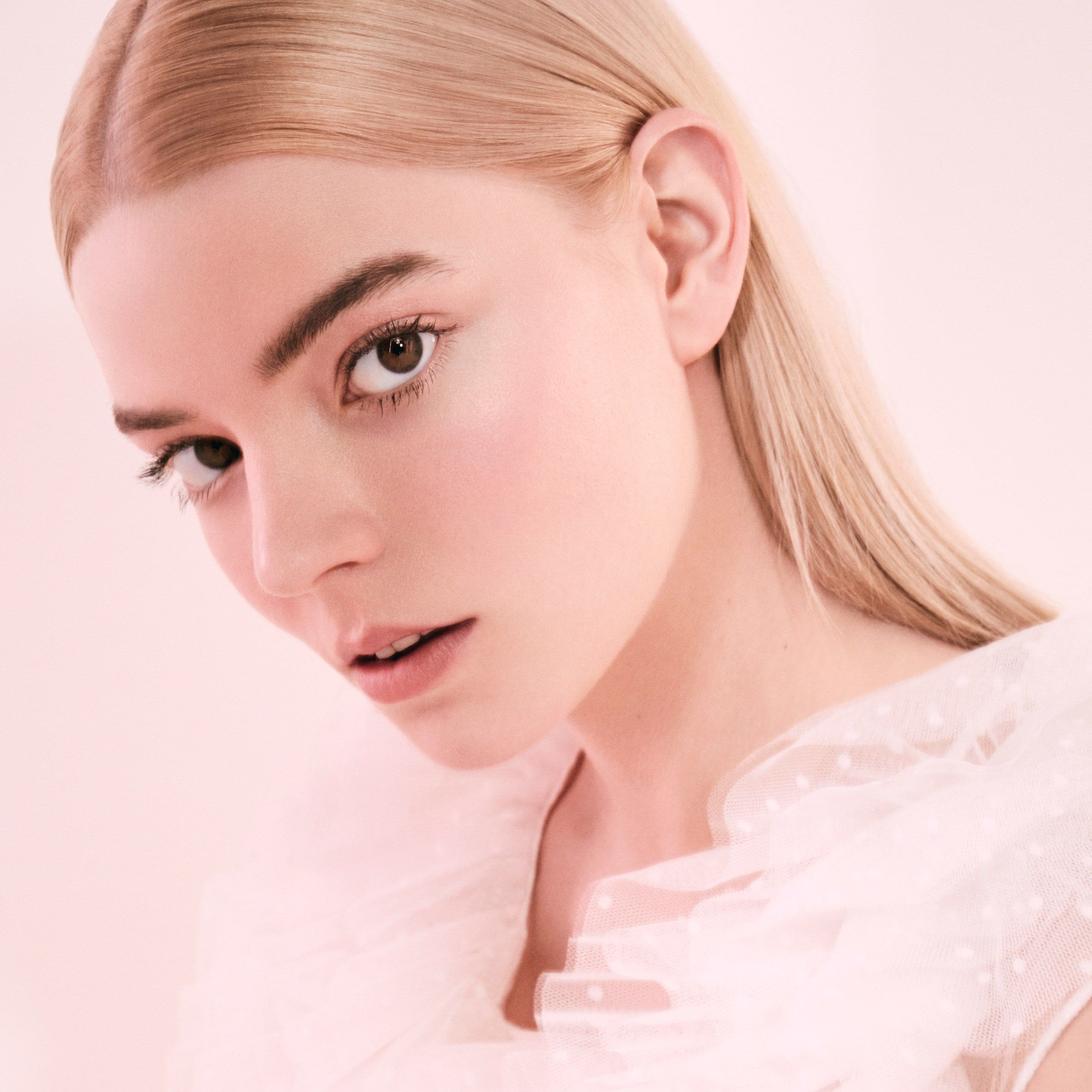 A woman with blonde hair and a white top. - Anya Taylor-Joy, pink