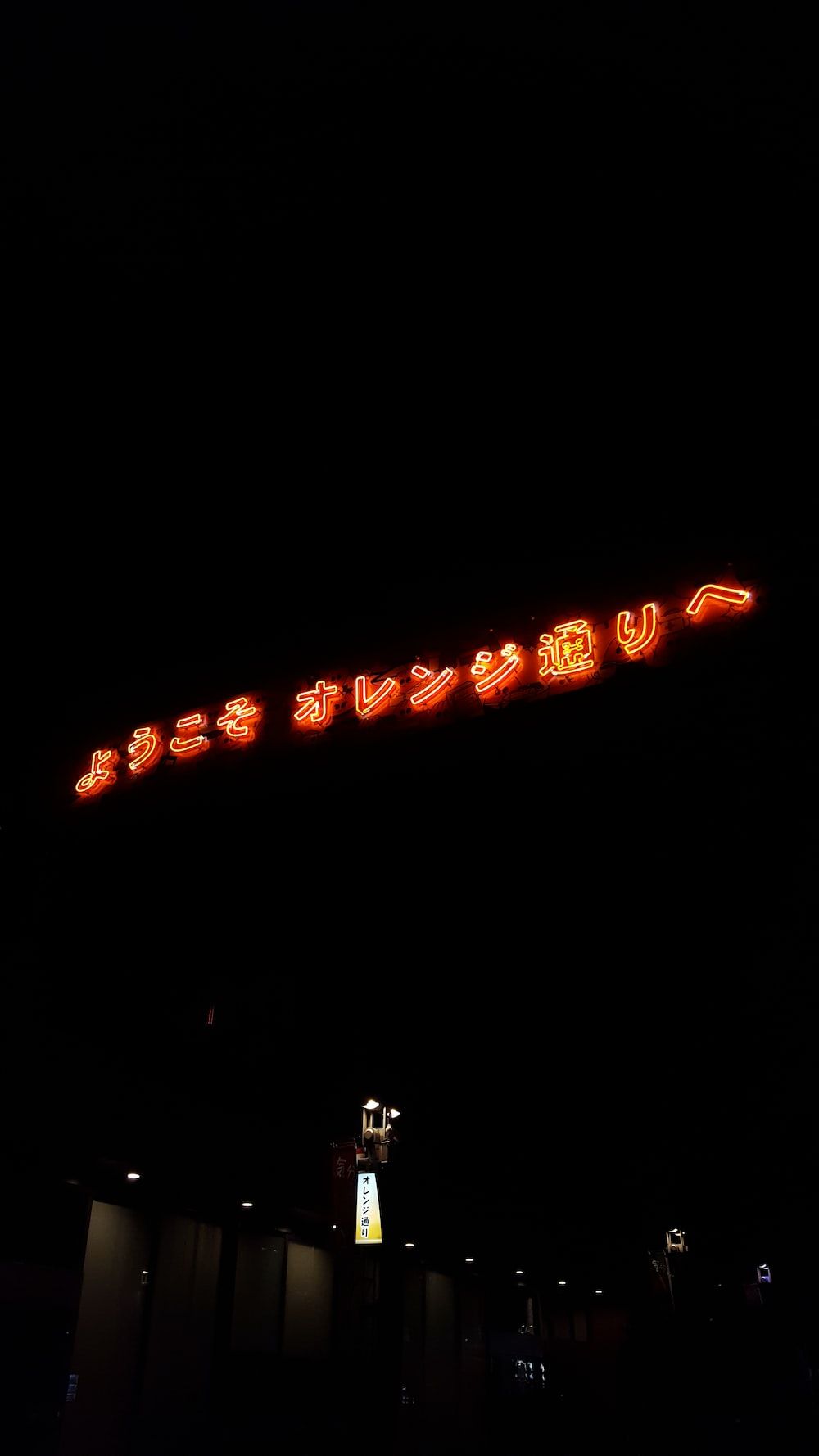 A sign that is lit up at night - Neon orange