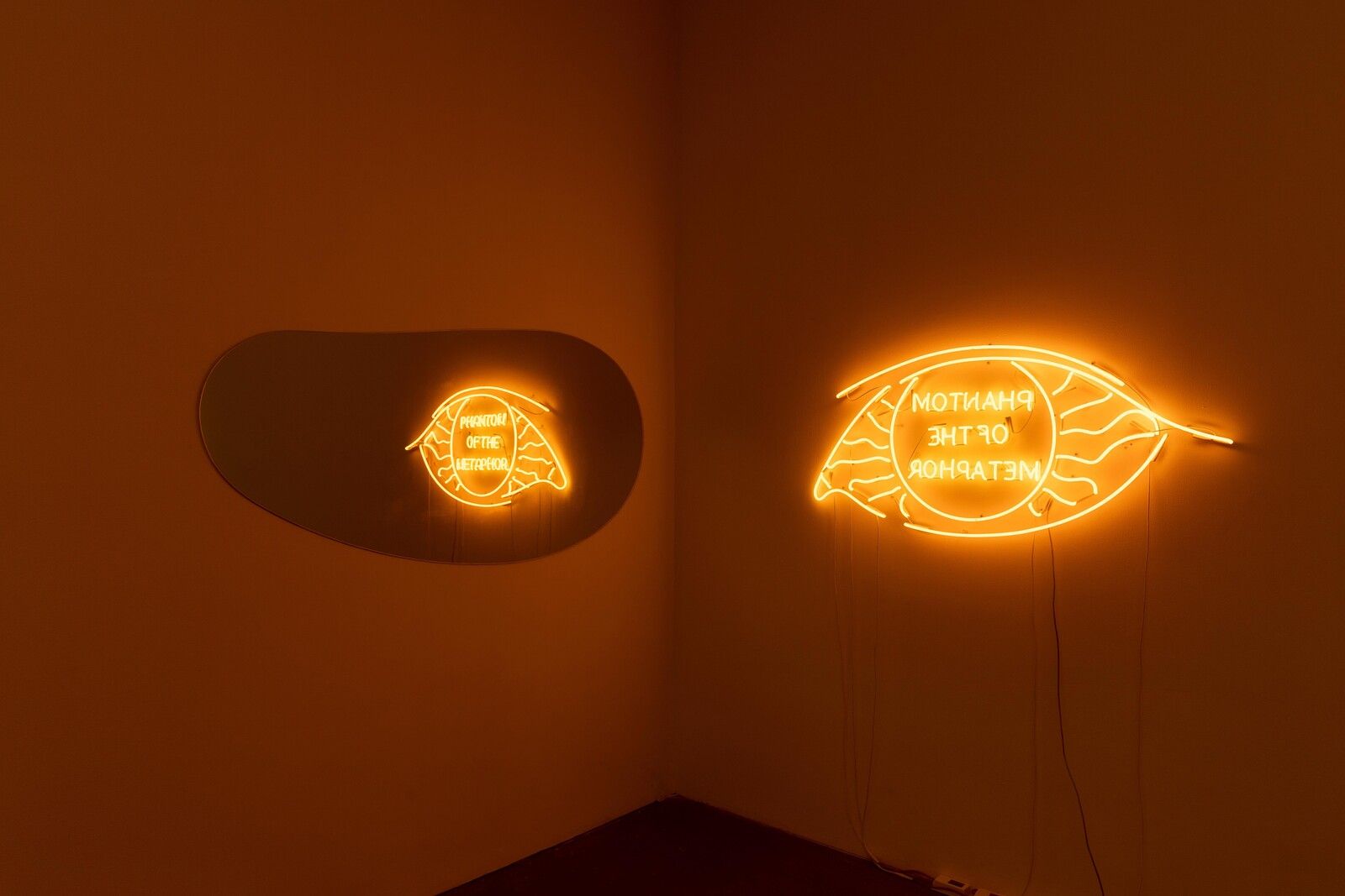 Two orange neon signs in the shape of leaves, one that says 